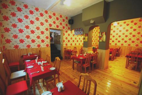 a restaurant with red tables and chairs in a room at The Curraghmore in Shanklin