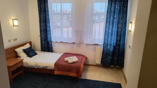 a small room with a bed and a window at Apart Hotel Sutoris in Bochnia