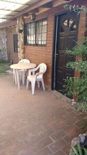 un patio con una mesa y 2 sillas y una puerta en Depto Caeiro Santa María en Santa María