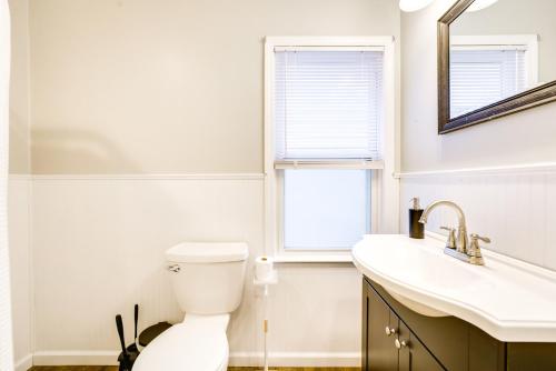 ein Bad mit einem WC, einem Waschbecken und einem Fenster in der Unterkunft WFH-Friendly Home in Dearborn Dogs Welcome! in Dearborn