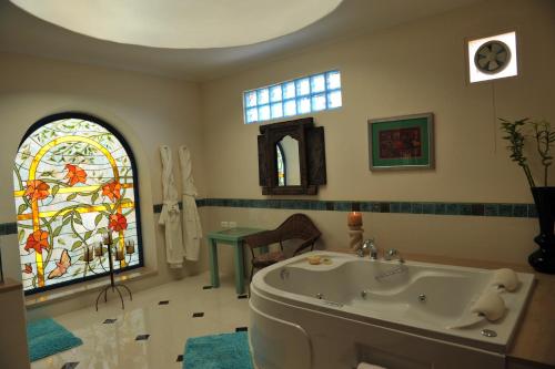 a bathroom with a tub and a stained glass window at Lazib Inn Resort & Spa in Tunis