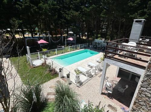 una piscina en un patio con sillas en Nereidas Apart en Mar de las Pampas