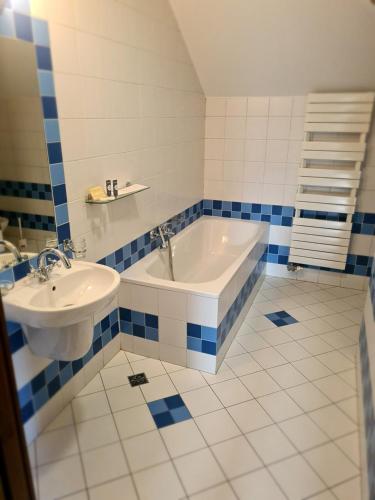 a blue and white bathroom with a tub and a sink at Hotel Sutoris in Bochnia
