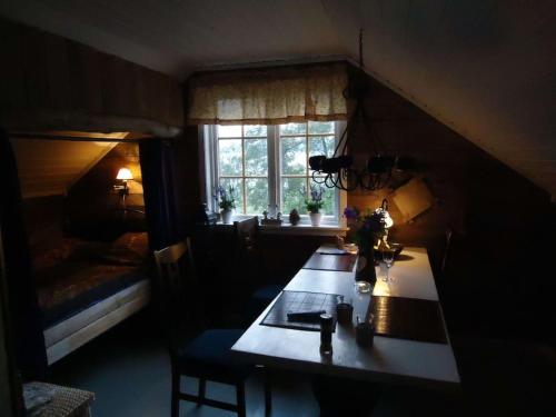 a room with a table and a bed and a window at House by the Sea in Sortland