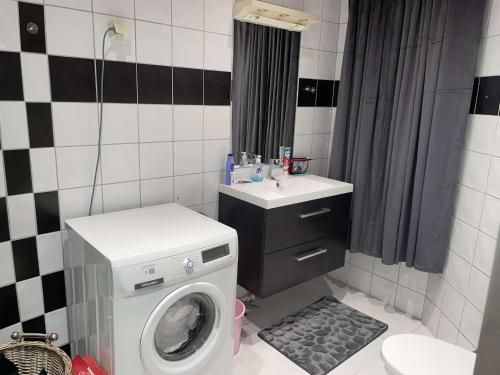 y baño con lavadora y lavamanos. en Rom midt i Oslo sentrum- gå avstand til det meste, en Oslo