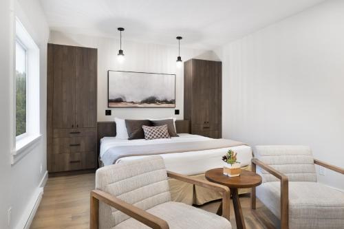 a hotel room with a bed and a table and chairs at West Coast Trail Lodge in Port Renfrew