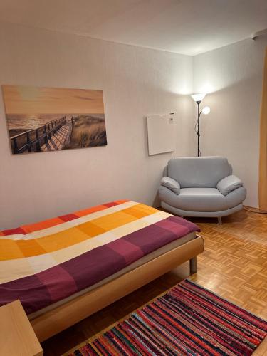 a bedroom with a bed and a chair at Premium Handwerker Zimmer in Balingen