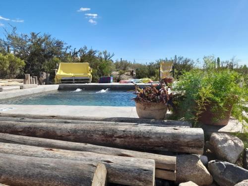 a swimming pool with two potted plants next to at Bendita Piedra Suites, Las Compuertas Lujan de Cuyo in Ciudad Lujan de Cuyo