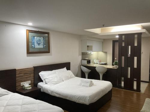 a hotel room with two beds and a kitchen at Monolocale Stay (Studio Apartment KBCP) in Kota Bharu