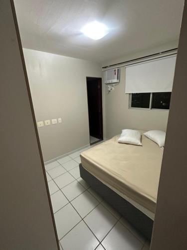 um pequeno quarto com uma cama e uma janela em Apartamento 80 m2 com dois quartos - João Pessoa em João Pessoa