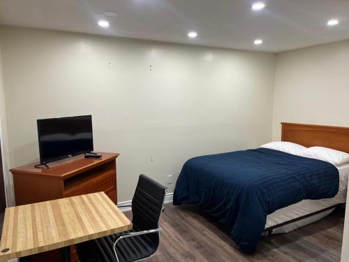 a bedroom with a bed and a desk and a tv at Cedar Springs Motel in Acton