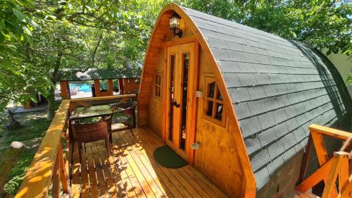 Cette petite cabane en bois dispose d'une véranda et d'une porte. dans l'établissement Cabañas Peñaflor Glamping, à Talagante