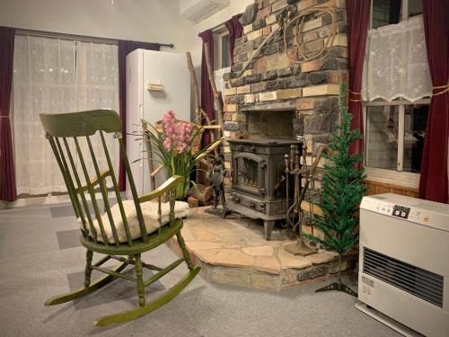 白马村Hakuba Snow Fox的客房设有壁炉、椅子和炉灶。