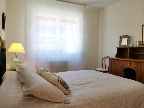 um quarto com uma cama com almofadas e uma janela em Apartamento Estriva em Ezcaray