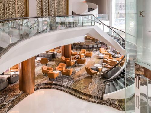 a spiral staircase in a lobby with chairs and tables at Novotel Kuala Lumpur City Centre in Kuala Lumpur