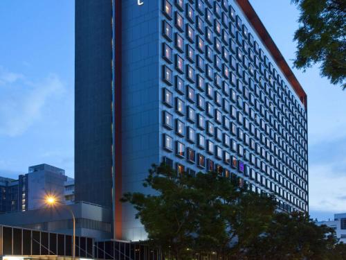 Ibis Singapore on Bencoolen في سنغافورة: مبنى طويل مع ضوء الشارع أمامه