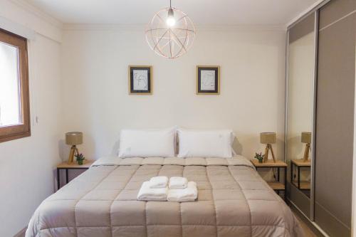 een slaapkamer met een bed met twee handdoeken erop bij LA TUA CASA in Bariloche