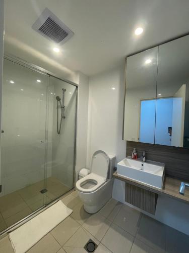 een badkamer met een toilet, een wastafel en een douche bij Entire 2 bedrooms Security Apartment in Riverwood
