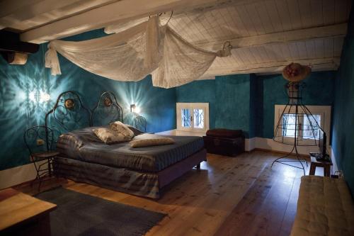 una camera con un letto in una stanza con pareti blu di Locanda Al Cappello a Udine