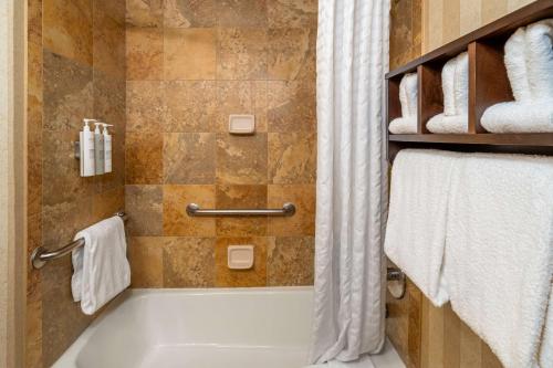 a bathroom with a tub and a shower with towels at Hampton Inn Nashville / Vanderbilt in Nashville