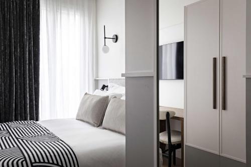 a white bedroom with a bed and a desk at Best Western Premier The Blake Paris Gare Saint Lazare in Paris