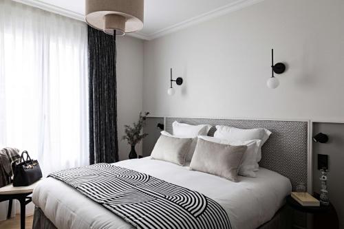 1 dormitorio blanco con 1 cama grande con almohadas blancas en Best Western Premier The Blake Paris Gare Saint Lazare, en París