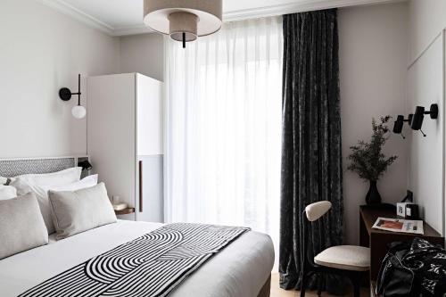 a bedroom with a bed and a large window at Best Western Premier The Blake Paris Gare Saint Lazare in Paris