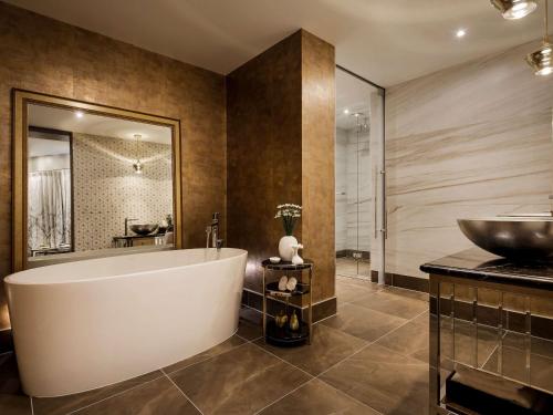 a bathroom with a large tub and a sink at Sofitel Wellington in Wellington