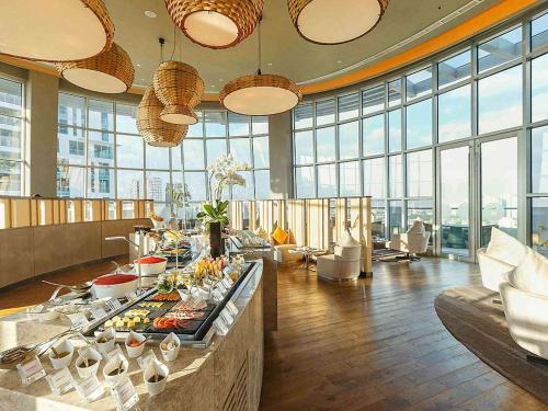 Habitación con buffet de comida en un edificio con ventanas en Novotel Manila Araneta City Hotel, en Manila