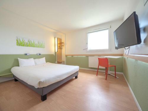 een slaapkamer met een bed en een flatscreen-tv bij Ibis Budget Sarrebourg Buhl in Sarrebourg