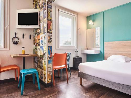 Habitación de hotel con cama, escritorio y TV. en hotelF1 Roissy CDG Pn2 en Roissy-en-France