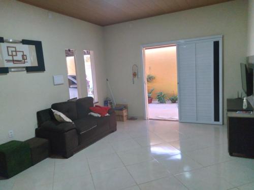 een woonkamer met een bank en een glazen schuifdeur bij Casa de praia caueira in Praia Da Caueira