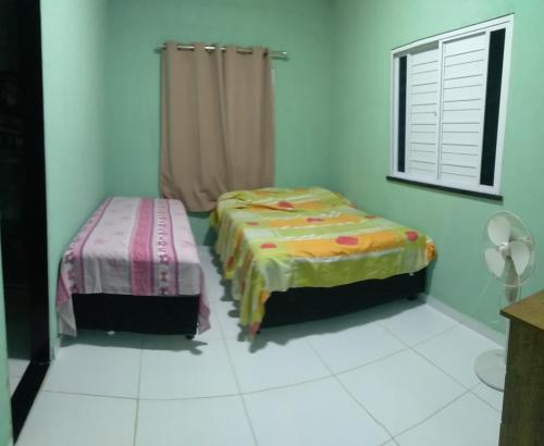 een kamer met 2 bedden en een raam erin bij Casa de praia caueira in Praia Da Caueira