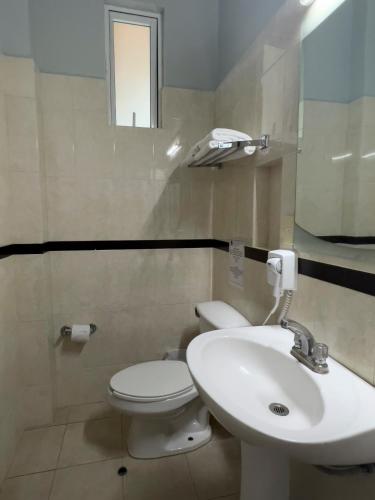 a bathroom with a white toilet and a sink at Hotel Principal in Mexico City