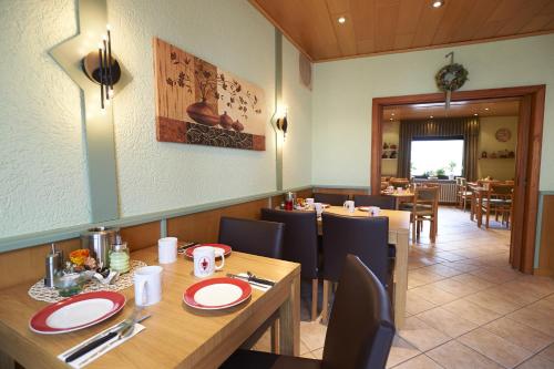 ein Esszimmer mit Tischen und Stühlen in einem Restaurant in der Unterkunft Mittelrhein Pension in Boppard