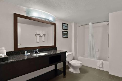 a bathroom with a sink and a toilet and a mirror at Comfort Inn & Suites Santee I-95 in Santee