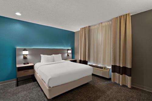 sypialnia z białym łóżkiem i niebieską ścianą w obiekcie Comfort Inn & Suites Santee I-95 w mieście Santee