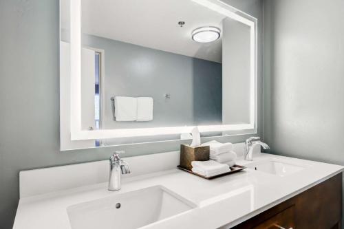 a bathroom with a white sink and a large mirror at Whitefish Riverfront Hotel in Whitefish
