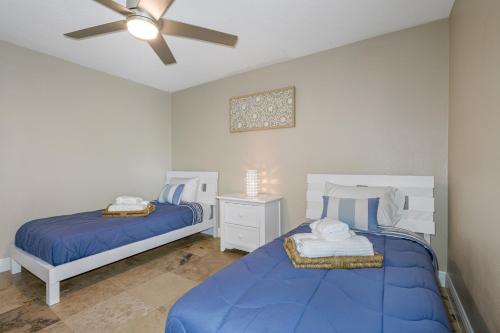 a bedroom with two beds and a ceiling fan at Tranquil Paradise 4BR - 2 Miles To Tampa Bucs Stadium in Tampa