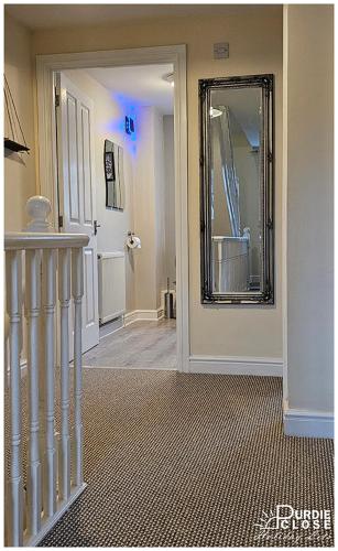 a hallway with a mirror on the wall and a staircase at Purdie Close Holiday Let in Cheddar