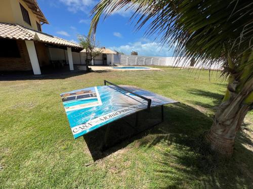 a swimming pool in a yard next to a palm tree at Casa de Praia no Morro Branco in Beberibe