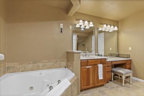 a bathroom with a tub and two sinks and a large mirror at 6bedrooms, ramp boat dock slips water toys, nice cove area in Linn Creek