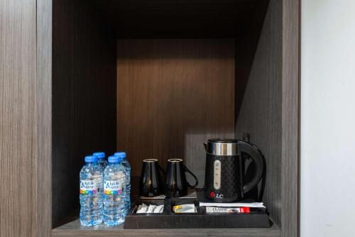a cupboard with bottles of water and a coffee maker at Best Western Ajyad Makkah in Makkah