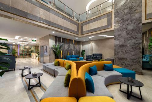 a lobby with a couch and a table and chairs at Best Western Ajyad Makkah in Makkah