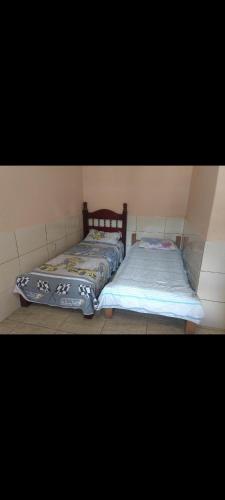 duas camas sentadas uma ao lado da outra num quarto em Recanto Renascer (hostel e Pousada) em Rio Branco