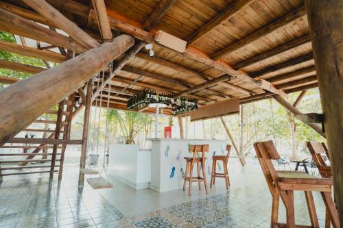 Zimmer mit Holzdecken, Tischen und Stühlen in der Unterkunft La Mar de Bien in Buritaca