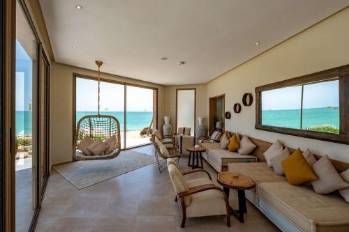 a living room with a couch and chairs and the ocean at Dakhla South Bay in Dakhla