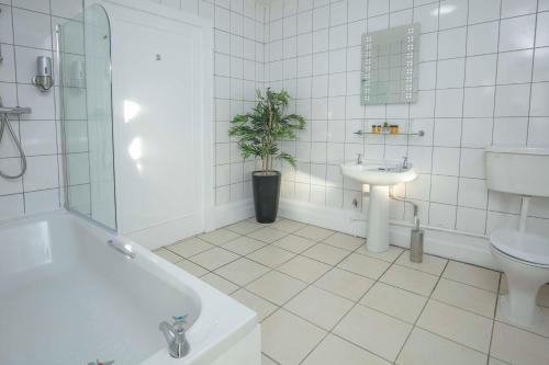 uma casa de banho branca com um lavatório e um WC em Best Western The Grand Hotel Hartlepool em Hartlepool