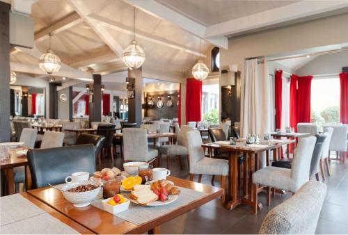 - un restaurant avec des tables et des chaises où vous pourrez manger dans l'établissement Best Western Hotel Acadie Paris Nord Villepinte, à Tremblay-en-France