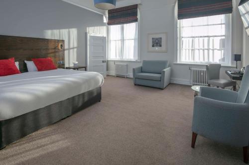 Best Western The Grand Hotel Hartlepool في هارتلبول: غرفة نوم بسرير كبير وكرسي